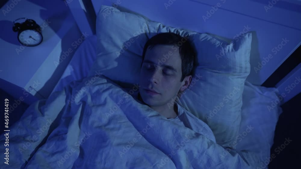 Man sleeping in his bed at night