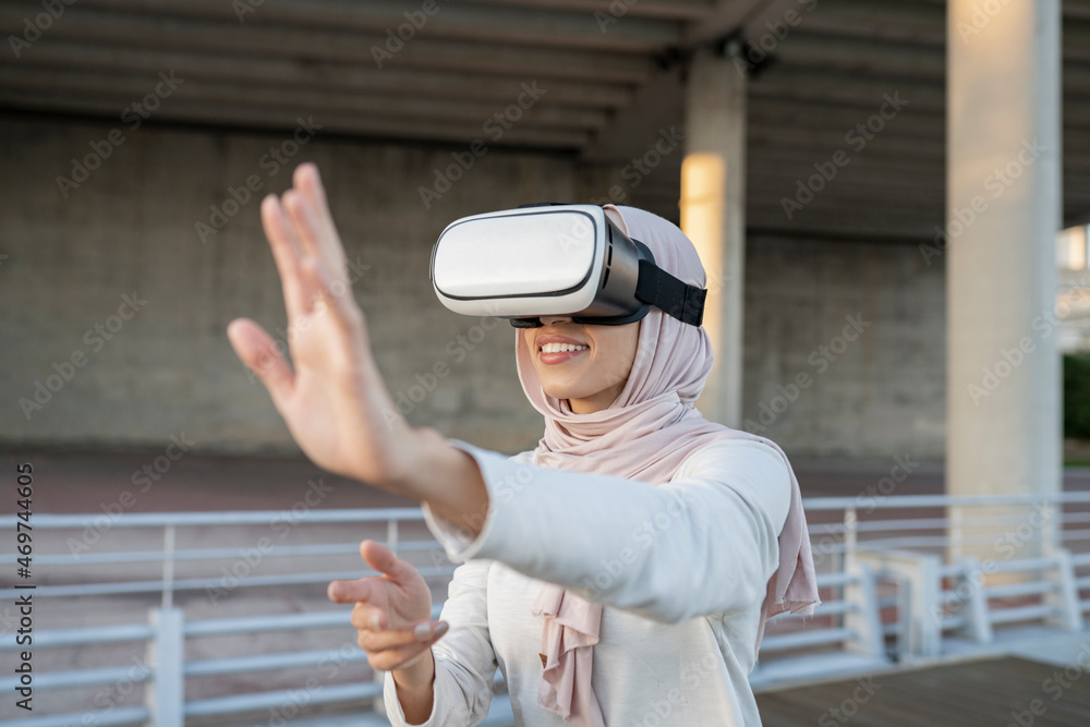 Arab woman in VR headset on embankment Arab woman in VR headset on embankment