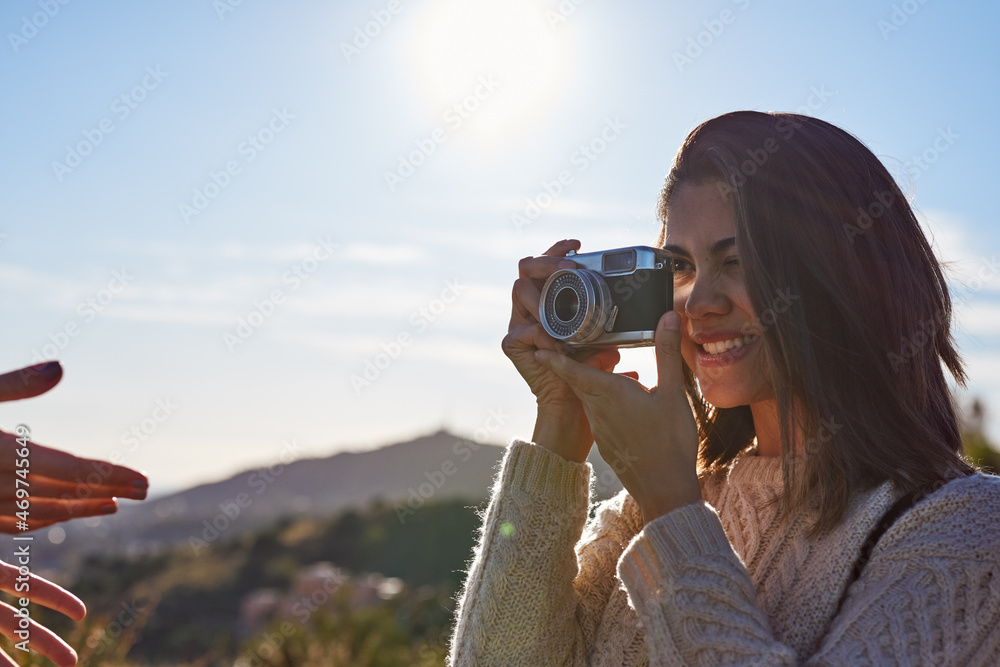 Woman photographig her friend in mountains Woman photographig her friend in mountains