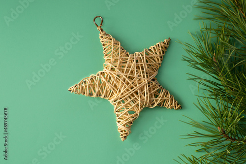 Wallpaper Mural Banner with rattan star and pine branches on a green background. Christmas picture with free space for text. Natural wooden rattan star.  Torontodigital.ca