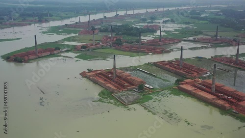 Aerial view of chimneys kilns from brick factory surrounding the area along Dhaleshwari river near Keraniganj township, Dhaka, Bangladesh. photo