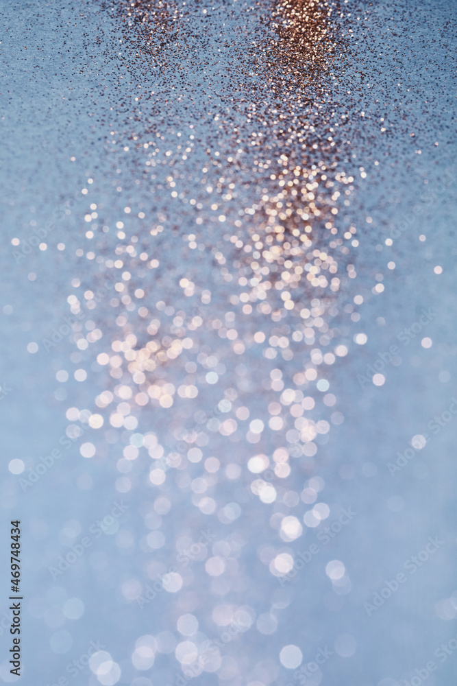 Blue festive background. Abstract scattering of gold sparkles. Christmas Winter backdrop, selective focus