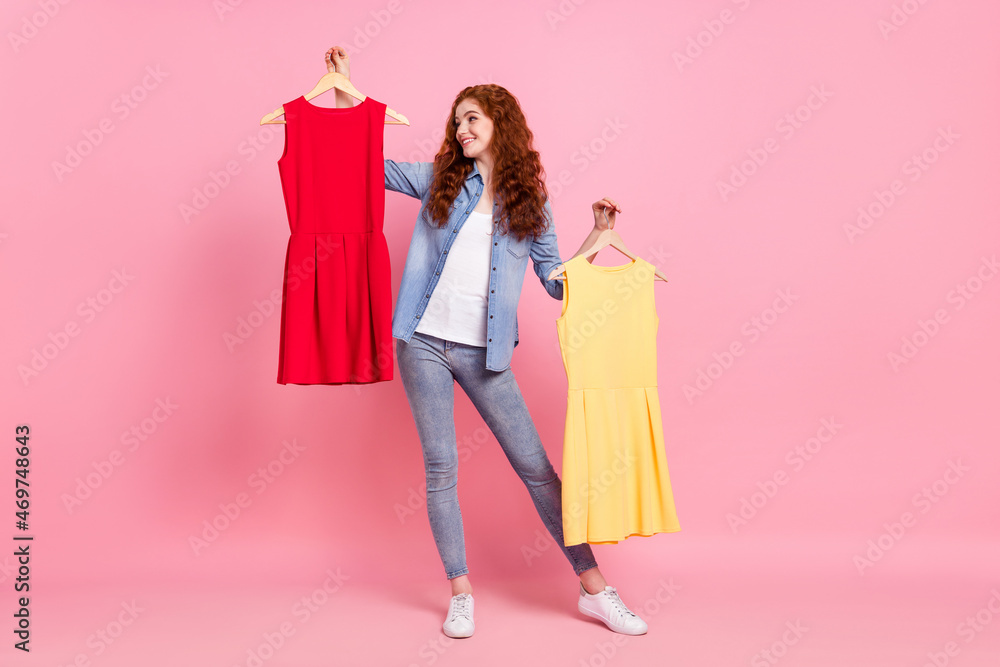 Full length photo of charming happy positive young woman hold hands dress choose isolated on pink color background