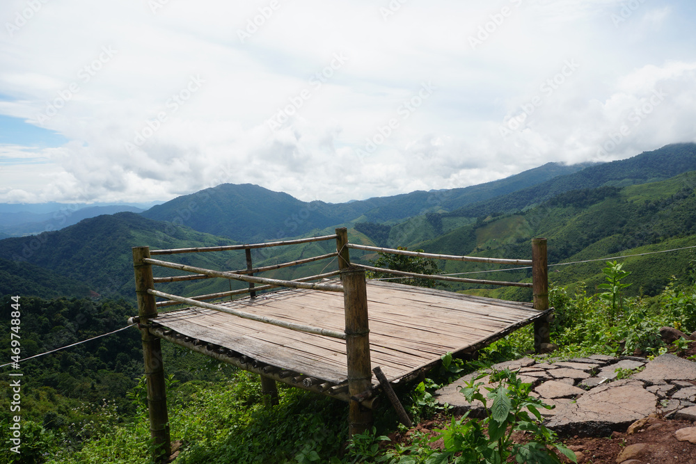 Bamboo terrace at the viewpoint on the top of the hill with beautiful landscape of mountains and clouds  in Doi Phu Kha National Park, Nan Province, Northern Thailand.