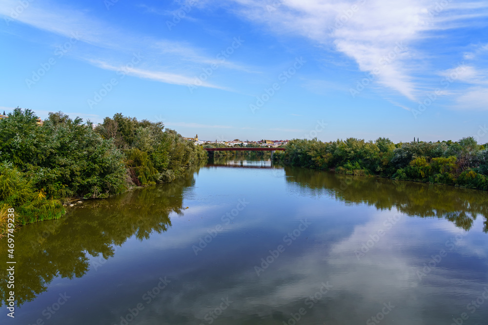 Guadalquivir river with reflections in the water as it passes through the city of Cordoba Spain.