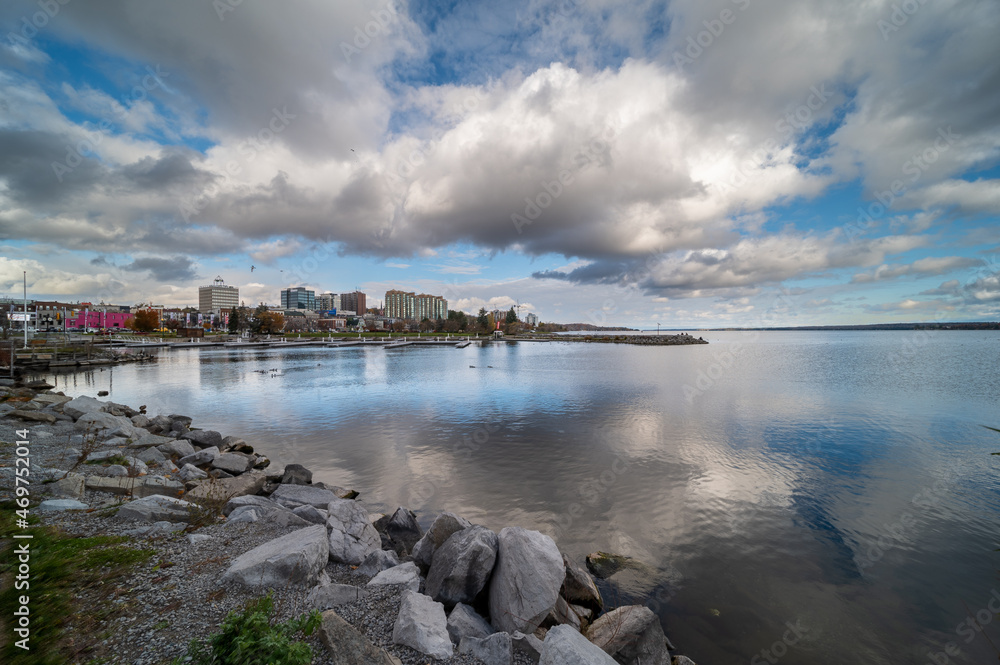 centennial park waterfront with clouds reflecting on the lake and the cost line ducks and rocks in the frame 