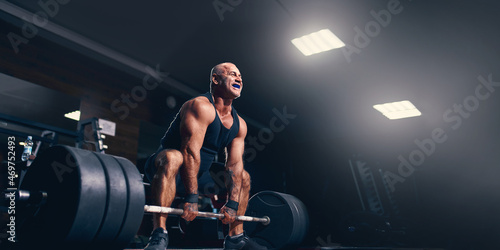 Photos Emotional older powerlifter preparing to exercise deadlift with barbell on cross