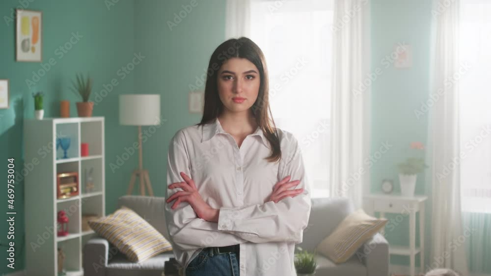 Portrait of young beautiful woman, dark-eyed brunette in casual outfit, standing in living room and looking at camera confidently, showing her natural beauty, Foreground, Slow motion. Portrait of young beautiful woman, dark-eyed brunette in casual outfit, standing in living room and looking at camera confidently, showing her natural beauty, Foreground, Slow motion.