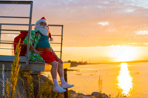 Fototapeta Naklejka Na Ścianę i Meble -  Santa Claus is walking on the beach at sunset