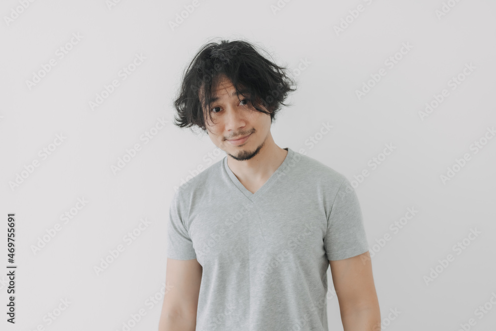 Chill and happy Asian man in his ordinary day with small smile and long hair. Chill and happy Asian man in his ordinary day with small smile and long hair.