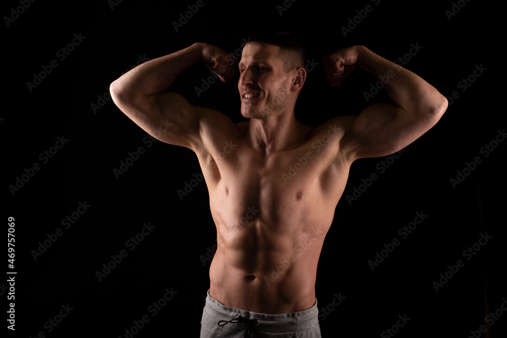 Man Showing Biceps Hands Up. Sportsman Showing Muscles. ABS, Biceps Muscles. Black Background. Topless Man Looking to Side Man Showing Biceps Hands Up. Sportsman Showing Muscles. ABS, Biceps Muscles. Black Background. Topless Man Looking to Side