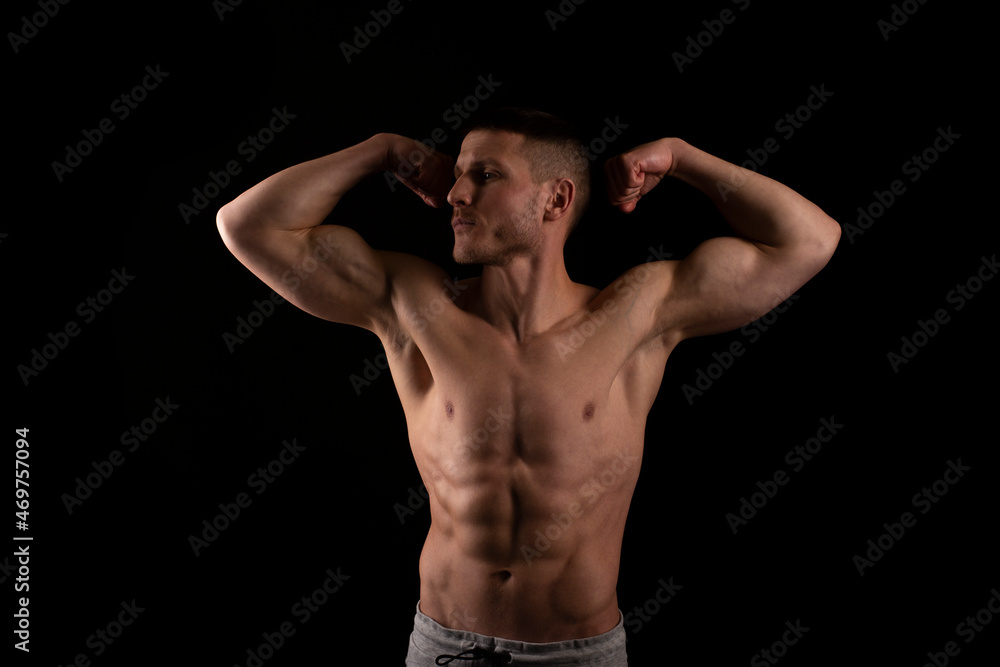 Man Showing Biceps Hands Up. Sportsman Showing Muscles. ABS, Biceps Muscles. Black Background. Topless Man Looking to Side Man Showing Biceps Hands Up. Sportsman Showing Muscles. ABS, Biceps Muscles. Black Background. Topless Man Looking to Side