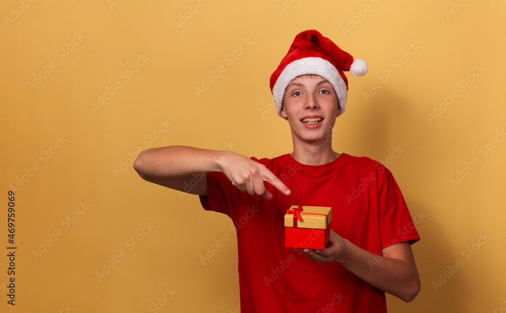 Portrait of a cute smiling boy in a Santa hat holding gift boxes. Portrait of a cute smiling boy in a Santa hat holding gift boxes.