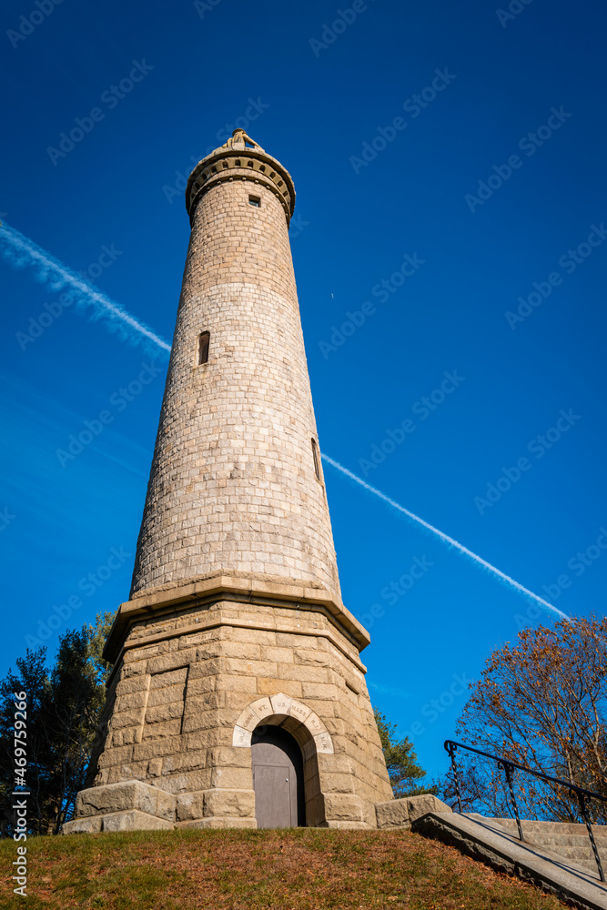 Tall Myles Standish Monument on blue sky background.