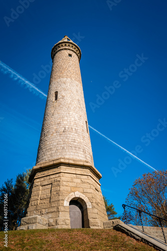 Tall Myles Standish Monument on blue sky background.