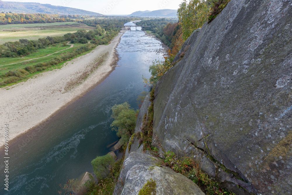 A rock above a mountain river with a fantastic view of the river valley, mountains and forests. Location natural rock complex A rock above a mountain river with a fantastic view of the river valley, mountains and forests. Location natural rock complex