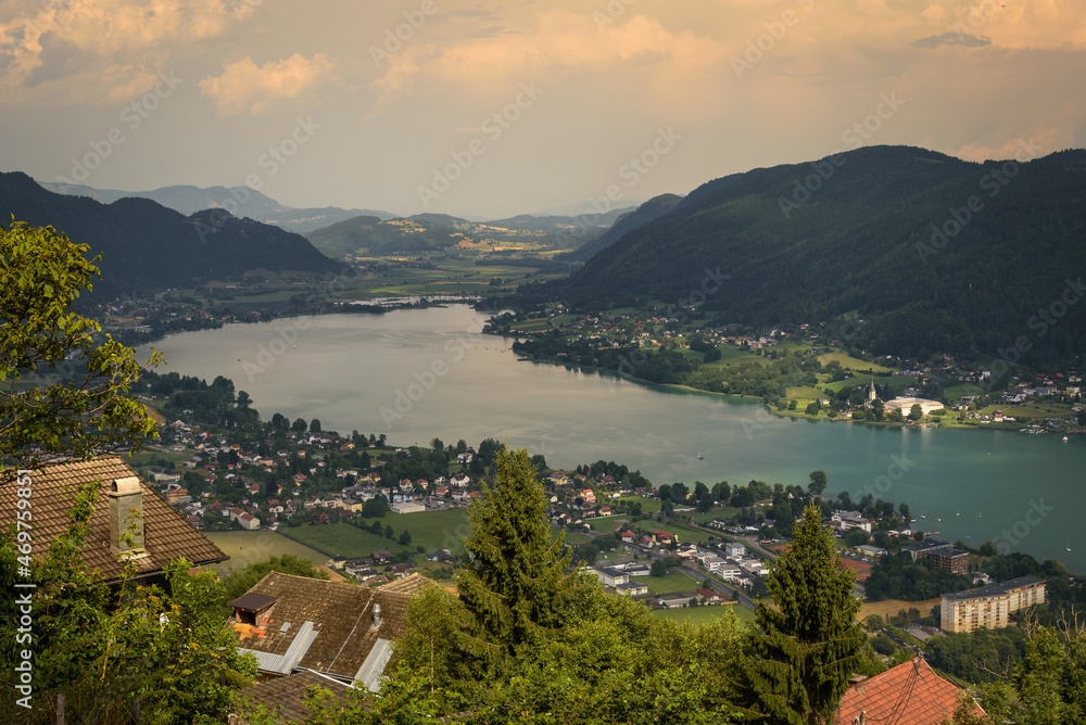 Panoramic view of the town of Pörtschach am Wörther See beside Wörthersee lake on a cloudy day in summer, Austria