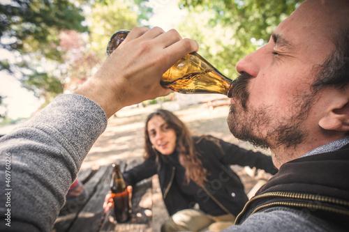 Картината върху платно Couple chugging bottle beer. Express drinking and fast get drunk