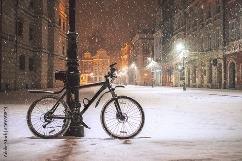 Bicycle at night while snowing at the old town