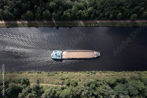Fototapeta Aerial top-down view of a self-propelled barge without cargo going along a narro
