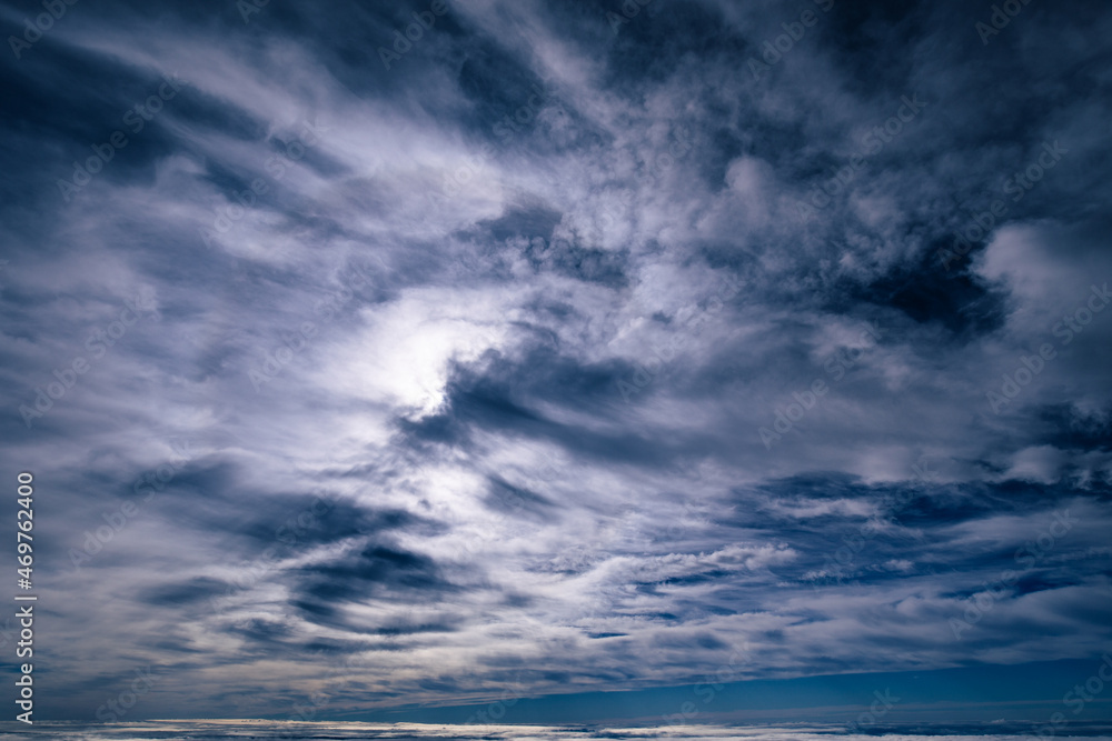 Dramatic cloudscape with light clouds covering the whole frame in bizarre pattern