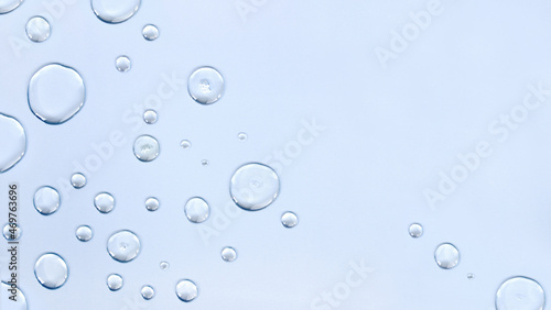 Transparent drops close-up on a light blue background. Top view, place for text