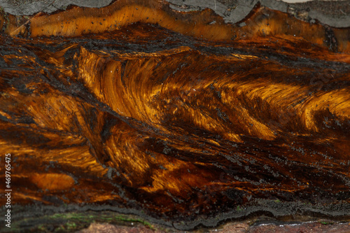 Macro stone tiger eye mineral in rock on black background