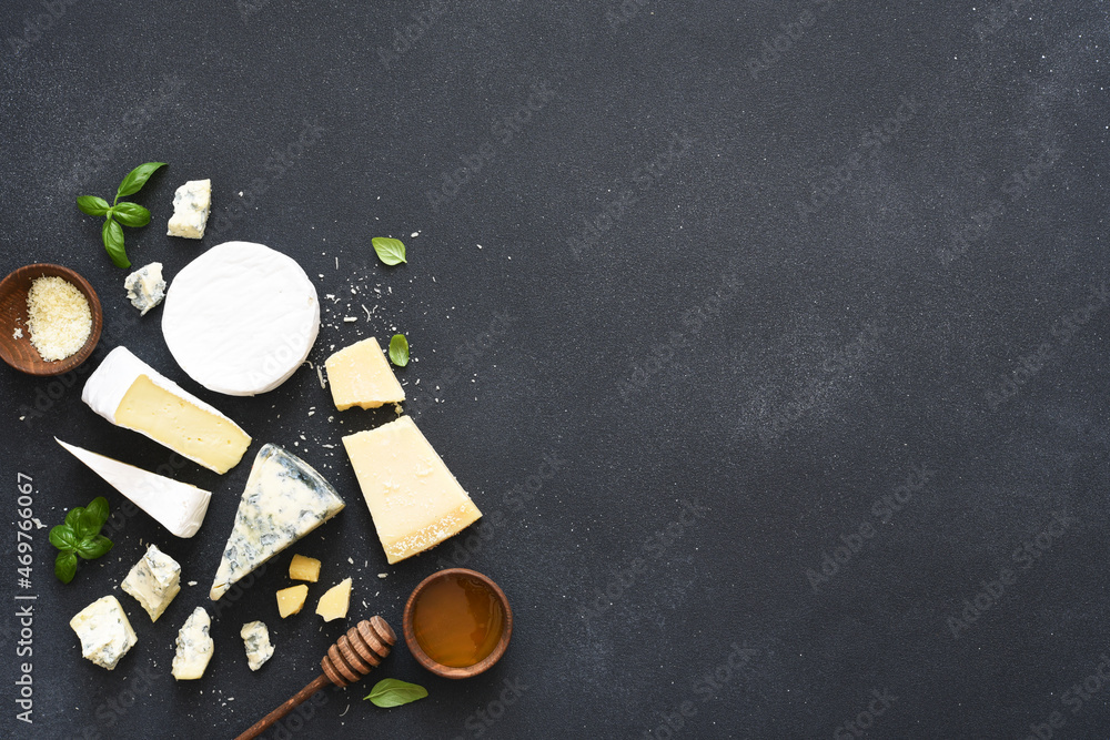 Set of cheeses: blue mold, parmesan, brie on a concrete black background.
