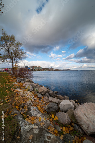 Barrie waterfront centennial park  lakeshore  path with green grass and fall colour trees   blue sky with broken clouds 