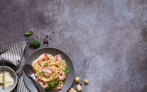 Spaghetti with shrimps, with sauce and parmesan on a concrete background. Top view. Menu. Shrimp pasta.
