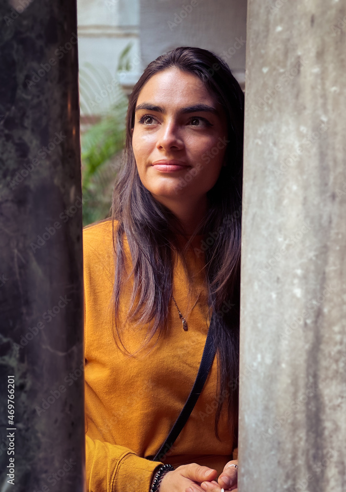 Narrow angle portrait of woman between pillars of dark and light. Narrow angle portrait of woman between pillars of dark and light.