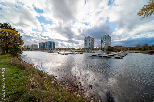 Barrie waterfront centennial park lakeshore path with green grass and fall colour trees blue sky with broken clouds 