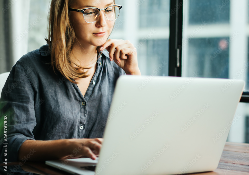 Young woman working with a laptop. Female freelancer connecting to internet via computer. Businesswoman at work Young woman working with a laptop. Female freelancer connecting to internet via computer. Businesswoman at work