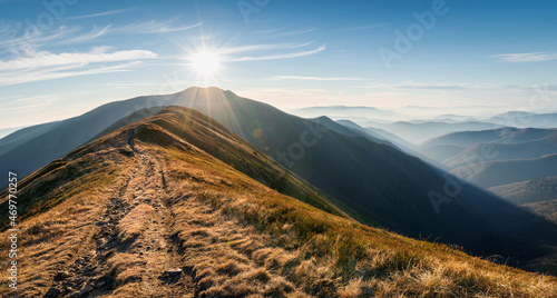 Winding road through meadows of mountain range at sunset. Beautiful landscape in the mountain. Location place Carpathian mountain, Ukraine, Europe. Beauty world. Panoramic view.