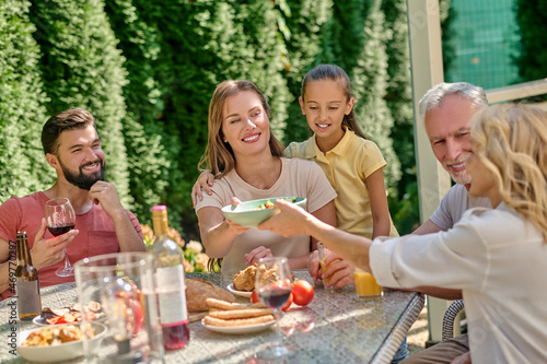 A family sitting at the dinner table and looking joyful