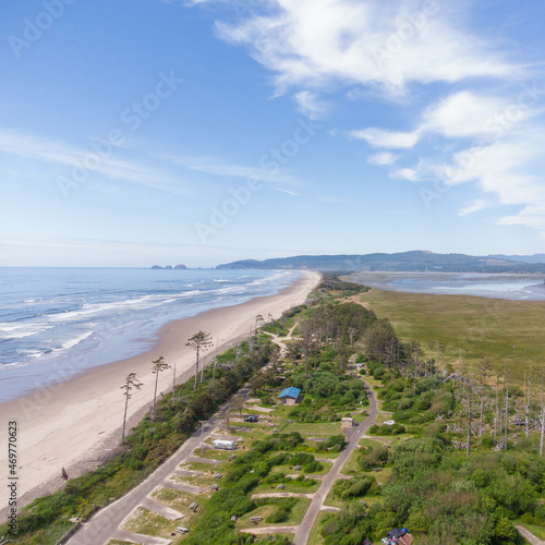 Picturesque coastal area. Ocean  sandy beach. There is a lot of greenery in the coastal area  blue sky with light clouds. Parking for cars. Deserted place. Rest  relaxation  romance  solitude.