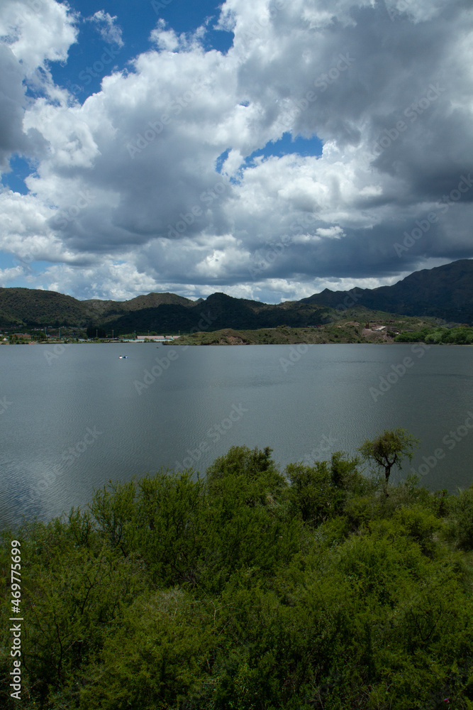 View of the reservoir Potrero de los Funes in San Luis, Argentina. The green forest, hills and lake under a dramatic sky with beautiful clouds.