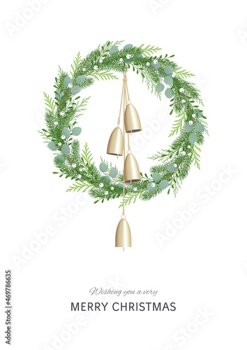 Christmas wreath with greenery, berries and golden bells hanging on rustic rope. Festive decoration in Scandinavian style. Greeting card. © Julia Laime