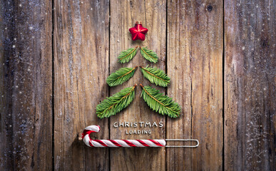 Christmas Loading Concept - Fir Tree And Candy Canes On Wooden Rustic Table