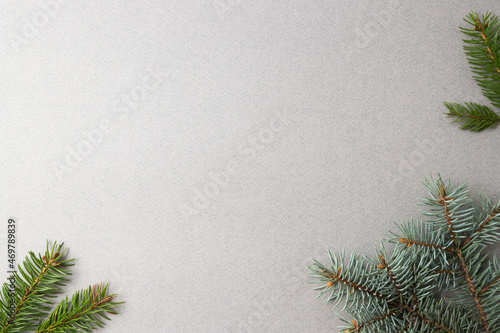 Fir twigs on a gray background, the basis for a Christmas and New Year greeting card 2022