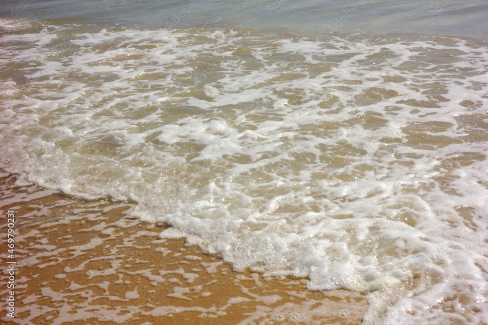 olas rompientes y espuma marina en la orilla del mar