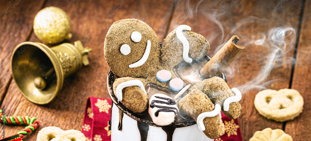 Gingerbread man cookie sitting inside christmas hot chocolate mug. Fun image on vacation or lounging on winter vacation Gingerbread man cookie sitting inside christmas hot chocolate mug. Fun image on vacation or lounging on winter vacation