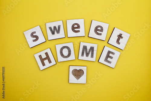 Wood cube letters with word sweet home on the yellow background