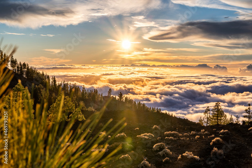 Wolken hängen am Berghang des Teide auf Teneriffa und werden von der untergehenden Sonne angestrahlt