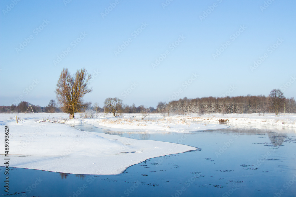 Winter landscape, january, the river flows through the valley