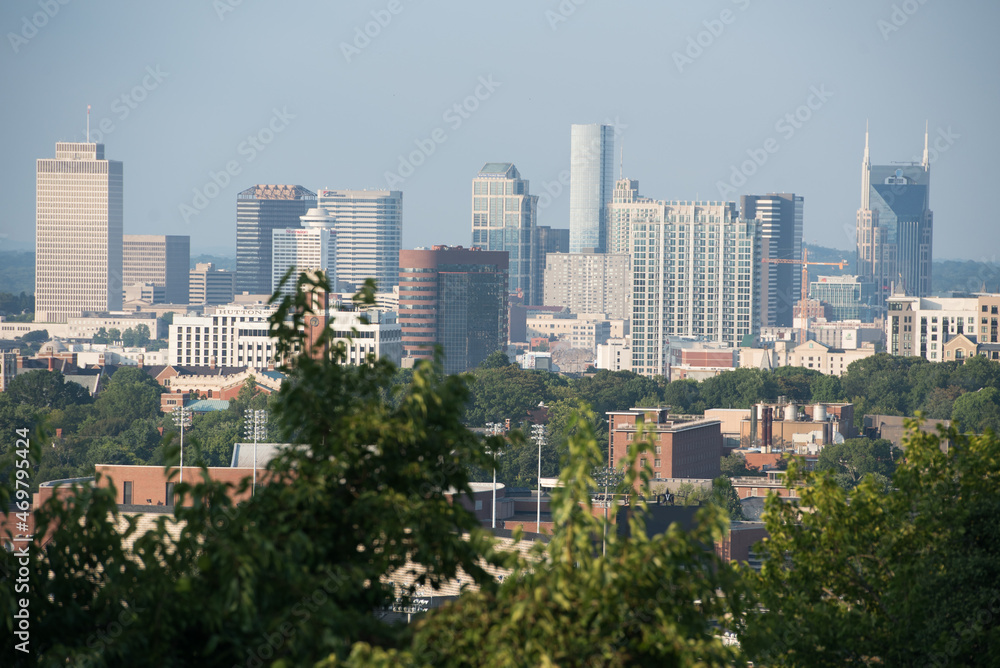 Nashville, TN cityscape with trees in the foreground and buildings in the background.