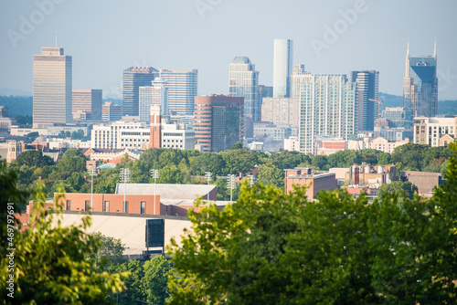 Nashville, TN cityscape with trees in the foreground and buildings in the background.