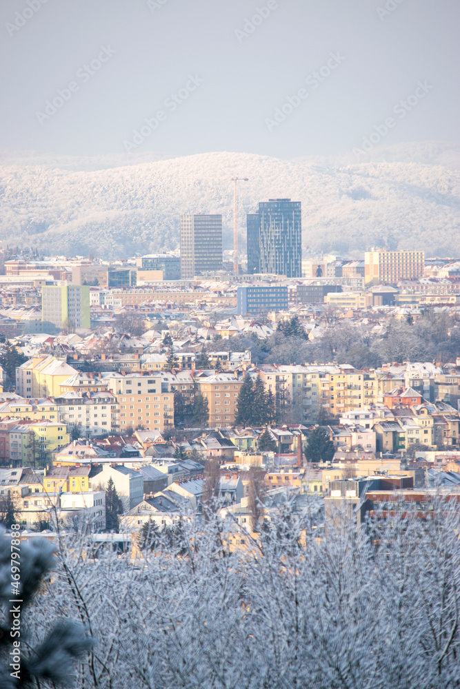 Panorama of the city of Brno in the Czech Republic in Europe in winter. Snow-covered trees, frozen houses and hills with snow in the distance.