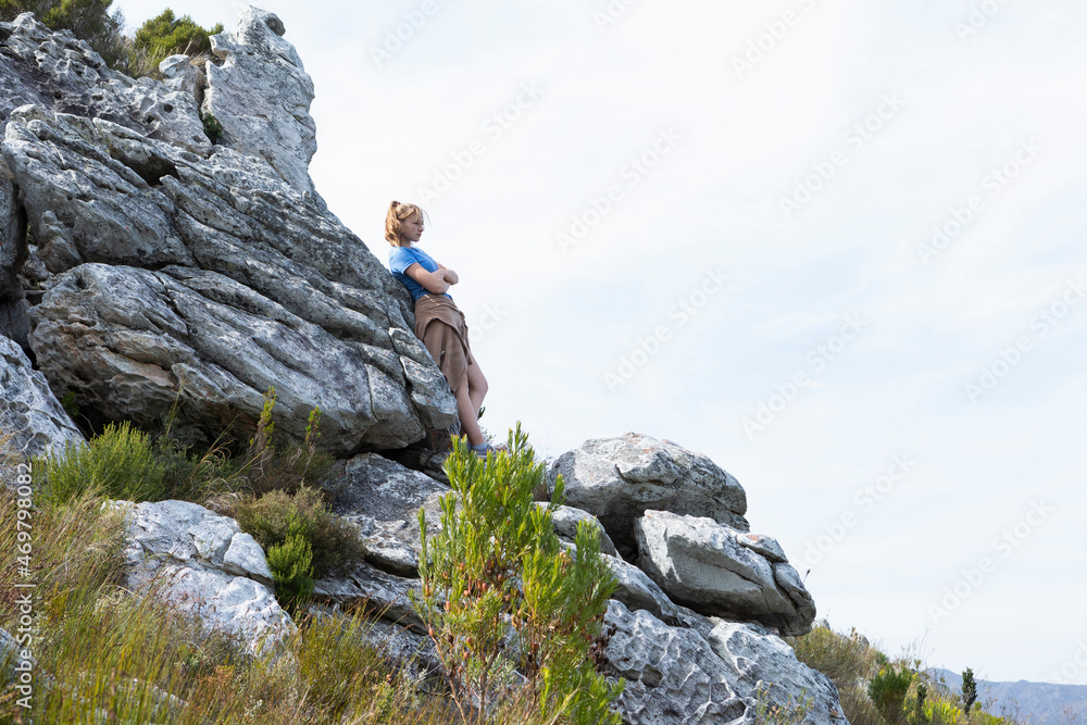 Teenage girl resting and looking out over the landscape Teenage girl resting and looking out over the landscape
