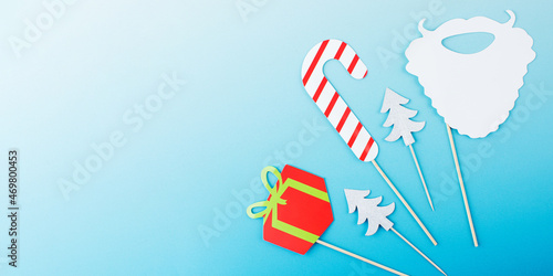Group of cute paper Christmas party attributes on light blue template banner. Copy space.